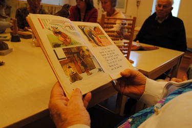 Person läser bok med teknade bilder samt text